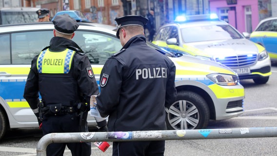 Polizeikräfte stehen an einer gesperrten Straße auf St. Pauli in Hamburg. © picture alliance Foto: Bodo Marks