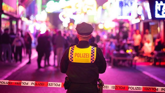 Ein Polizist steht vor einem Absperrband in der Großen Freiheit. © picture alliance/dpa Foto: Jonas Walzberg