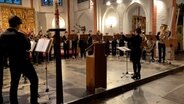 Ein Posaunenchor tritt in einer Kirche auf. © NDR Screenshot Foto: Screenshot