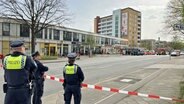 Einsatzkräfte stehen in der Nähe einer abgesperrten Postbank-Filiale in Hamburg-Lurup. © NDR Foto: Ingmar Schmidt