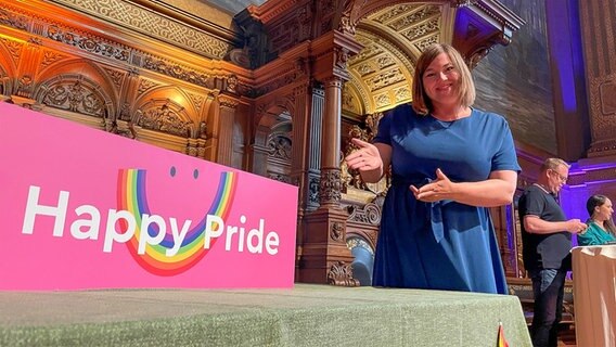 Hamburgs Zweite Bürgermeisterin Katharina Fegebank (Grüne) steht  im Festsaal des Hamburger Rathauses neben einem Plakat mit der Aufschrift " Happy Pride". © NDR Foto: Jörn Straehler-Pohl