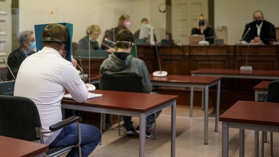 Die beiden 35-jährigen Angeklagten (2.v.l. und 4.v.l.) im Prozess wegen versuchten Mordes warten auf den Beginn der Verhandlung in einem Saal im Landgericht Hamburg © picture alliance/dpa Foto: Axel Heimken