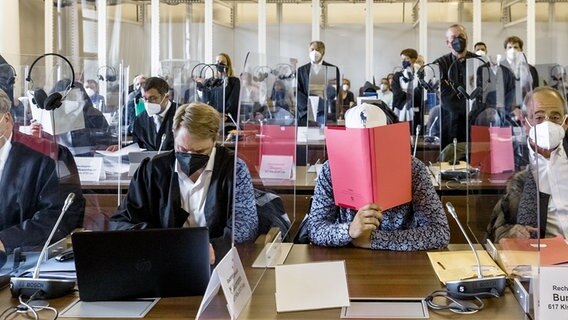 Missbrauchsprozess: Angeklagte verbergen in einem Gerichtssaal des Hanseatischen Oberlandesgerichts ihre Gesichter. © picture alliance/dpa Foto: Markus Scholz