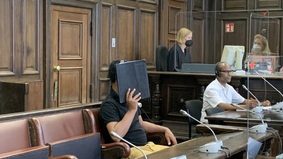 Ein Angeklagter sitzt vor einem Hamburger Gericht. Sein Gesicht ist verdeckt. © NDR Foto: Elke Spanner