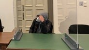 Ein Angeklagter sitzt im Saal des Amtsgerichts Hamburg. Er soll heimliche Aufnahmen von Kolleginnen in der Umkleide gemacht haben. © NDR Foto: Elke Spanner
