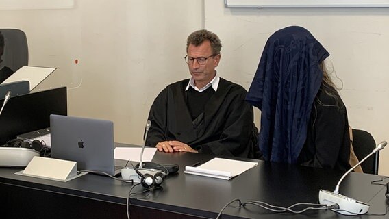 Eine Angeklagte verdeckt ihr Gesicht im Saal des Hamburger Landgerichts. Sie soll ihrem Ex-Partner Messerstiche zugefügt haben. © NDR Foto: Elke Spanner