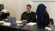 Eine Angeklagte verdeckt ihr Gesicht im Saal des Hamburger Landgerichts. Sie soll ihrem Ex-Partner Messerstiche zugefügt haben. © NDR Foto: Elke Spanner