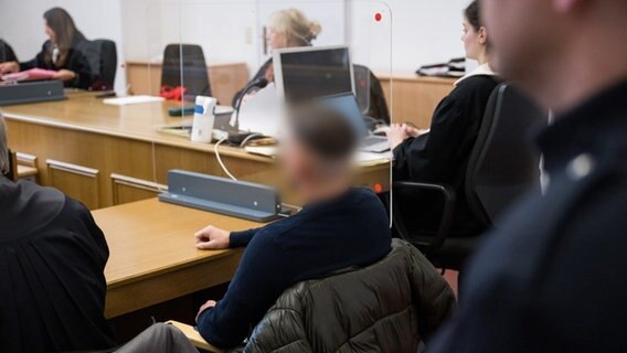 Ein Angeklagter sitzt vor Prozessbeginn in einem Gerichtssaal in Hamburg. Er soll auf der Reeperbahn einer Transfrau mit der Faust ins Gesicht geschlagen haben. © picture alliance / dpa Foto: Daniel Reinhardt