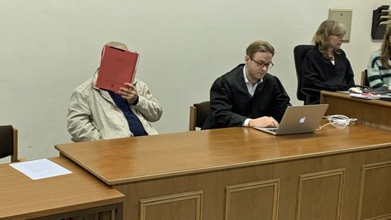 Ein Angeklagter verdeckt im Gerichtssaal sein Gesicht. © NDR Foto: Elke Spanner
