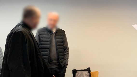 Ein Angeklagter steht mit einem Anwalt in einem Prozesssaal. © NDR Foto: Elke Spanner