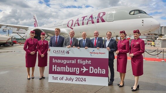 Umringt von Flugbegleiterinnen stehen Christian Kunsch (l-r), CEO von Hamburg Airport, Thierry Antinori, Chief Commercial Officer von Qatar Airways, Peter Tschentscher (SPD), Erster Bürgermeister von Hamburg, Lothar Freischlader, Botschafter der Bundesrepublik Deutschland in Katar, und Malte Heyne, CEO der Handelskammer Hamburg, bei einem Pressetermin zum ersten Flug der Fluggesellschaft Qatar Airways von Doha zum Hamburger Flughafen auf dem Rollfeld vor einem A 350. © picture alliance / dpa Foto: Georg Wendt