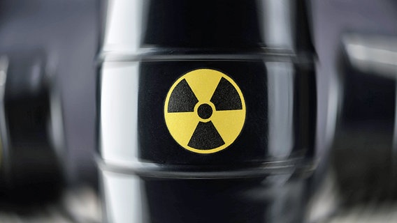 Das Zeichen für Radioaktivität auf einem schwarzen Atommüllfass.  