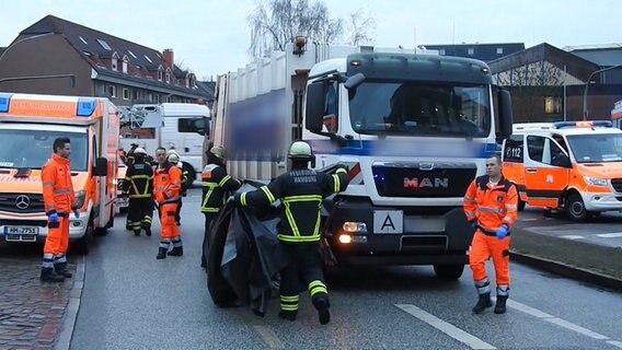 Toter Radfahrer wird mit Plane zugedeckt. © TeleNewsNetwork Foto: Screenshot