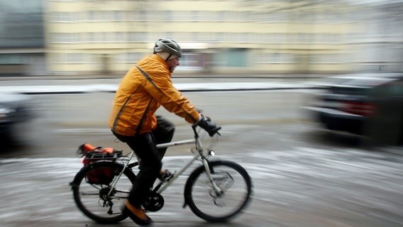 Ein Radfahrer fährt bei Schnee und Eis auf einem Radweg. © picture alliance / dpa Foto: Malte Christians