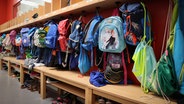 Sporttaschen und Schulranzen hängen an der Garderobe in einer Grundschule in Hamburg. © picture alliance / dpa Foto: Christian Charisius