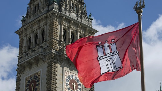 Der Rathausturm mit der Flagge von Hamburg im Vordergrund. © picture alliance / dpa Foto: Ulrich Baumgarten