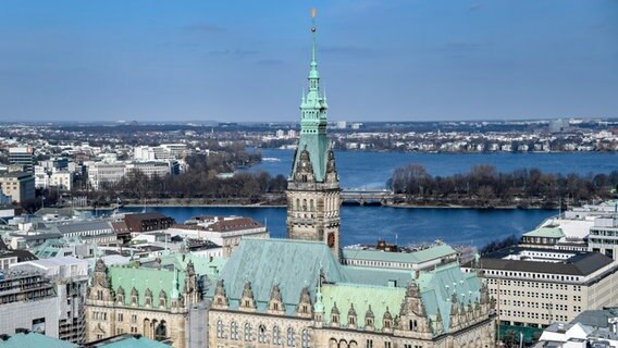 Die Sonne scheint vom blauen Himmel auf das Hamburger Rathaus an der Binnen- und Außenalster. © picture alliance/dpa Foto: Axel Heimken