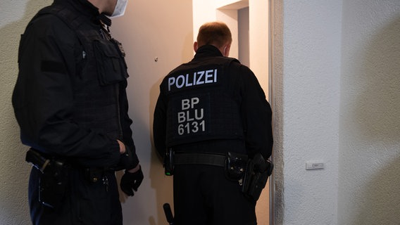 Zwei Bundespolizisten gehen bei einer Razzia in eine Wohnung. © picture alliance/dpa/dpa-Zentralbild | Paul Zinken Foto: Paul Zinken