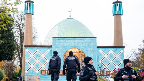 Einsatzkräfte der Polizei stehen während einer Razzia beim islamischen Zentrum Hamburg vor der Imam Ali Moschee (Blaue Moschee) an der Außenalster. © dpa Foto: Daniel Bockwoldt