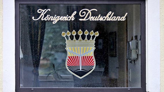 Das Logo des verbotenen Vereins "Königreich Deutschland" prangt an einem Fenster. (Archivfoto) © picture alliance / Jan Woitas/dpa-Zentralbild/dpa 