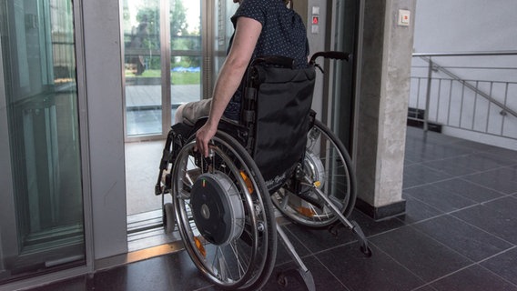Ein Rollstuhlfahrer fährt in einem Gebäude in einen Fahrstuhl. © picture alliance / dpa | Patrick Seeger Foto: Patrick Seeger