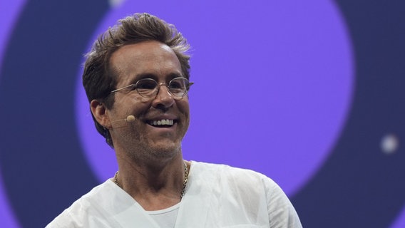 Schauspieler und Unternehmer Ryan Reynolds steht auf der Bühne während der Digitalmesse OMR. © Marcus Brandt/dpa 