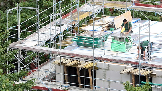 Arbeiter stehten auf der Baustelle eines Mehrfamilienhauses der SAGA GWG in Hamburg. © dpa Foto: Bodo Marks