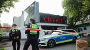 Polizeibeamte stehen vor einer Shisha-Bar im Hamburger Stadtteil Sasel. In der Nacht zuvor ein Mann dort erschossen worden. © picture allaince / dpa Foto: Christian Charisius