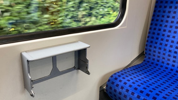 In einer Hamburger S-Bahn fehlt beim grauen Müllbehälter die Klappe, die zwischen die Sitzreihen im Waggon hängt. © NDR / Reinhard Postelt Foto: Reinhard Postelt