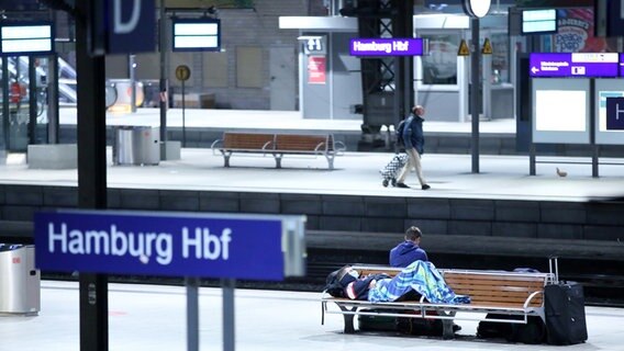 Zum Teil schlafend warten Reisende auf Bänken im Hauptbahnhof auf einen Zug. © dpa-Bildfunk Foto: Bodo Marks