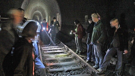 Besucher blicken auf von entgleisten Zügen aufgeschnittene Schwellen im Schellfischtunnel. © NDR Foto: Daniel Sprenger