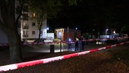 Polizisten stehen im Dunkeln vor Hochhaus hinter Absperrband © TV News Kontor 
