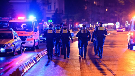 Polizisten laufen bei einem Einsatz wegen einer Massenschlägerei auf der Grindelallee in Hamburg. © picture alliance/dpa Foto: Jonas Walzberg