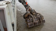 Der Saugkopf eines Baggerschiffes wird in die Elbe gesenkt. © picture alliance/dpa | Daniel Reinhardt Foto: Daniel Reinhardt