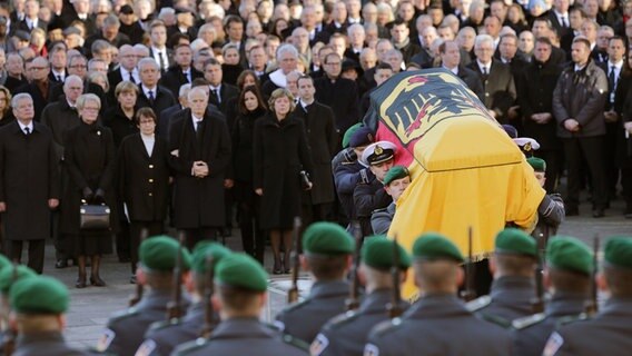 Der mit einer Fahne bedeckte Sarg des ehemaligen Bundeskanzlers Helmut Schmidt  wird von Soldaten nach dem Staatsakt aus der St. Michaeliskirche in Hamburg getragen. © dpa-Bildfunk Foto: Axel Heimken