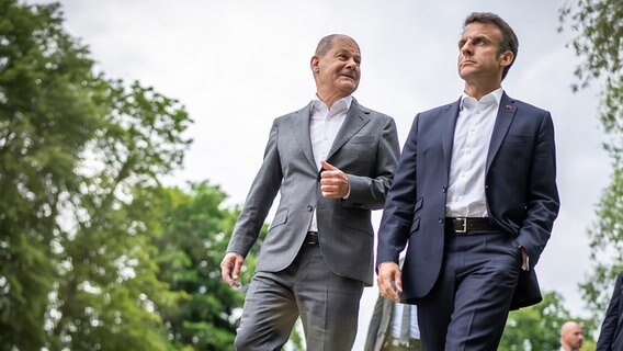 Bundeskanzler Olaf Scholz (SPD, l) geht mit Emmanuel Macron, Präsident von Frankreich, zu einem gemeinsamen Abendessen in Potsdam. © picture alliance/dpa/dpa Pool Foto: Michael Kappeler
