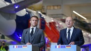 Bundeskanzler Olaf Scholz (r, SPD) und Emmanuel Macron, Staatspräsident von Frankreich, geben ein gemeinsames Statement nach dem Besuch auf dem Airbus-Werksgelände in Hamburg-Finkenwerder ab. © picture alliance/dpa | Marcus Brandt Foto: Marcus Brandt