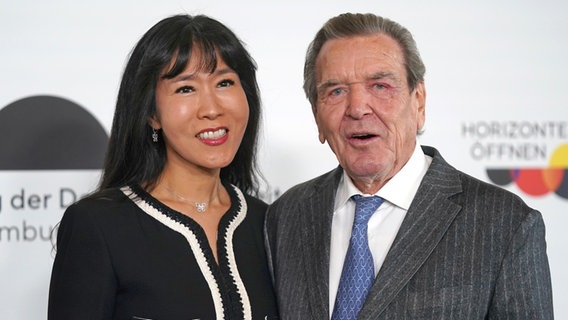 Gerhard Schröder (SPD), ehemaliger Bundeskanzler, und seine Ehefrau Soyeon Schröder-Kim kommen auf die Plaza der Elbphilharmonie zum Festakt. © picture alliance/dpa | Marcus Brandt Foto: Marcus Brandt