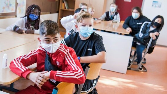 Schüler der Max-Schmeling-Stadtteilschule sitzen zu Beginn des Unterrichts mit Mund-Nasen-Bedeckungen im Klassenraum. © picture alliance / dpa Foto: Daniel Bickwoldt