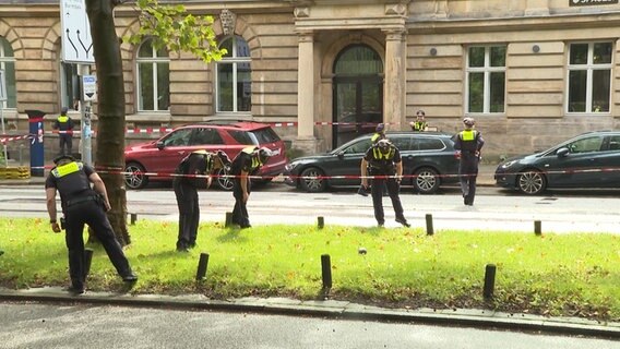 Einsatzkräfte der Polizei suchen einen Grpnstreifen am Gorch-Fock-Wall ab. © TVNewsKontor Screenshot 