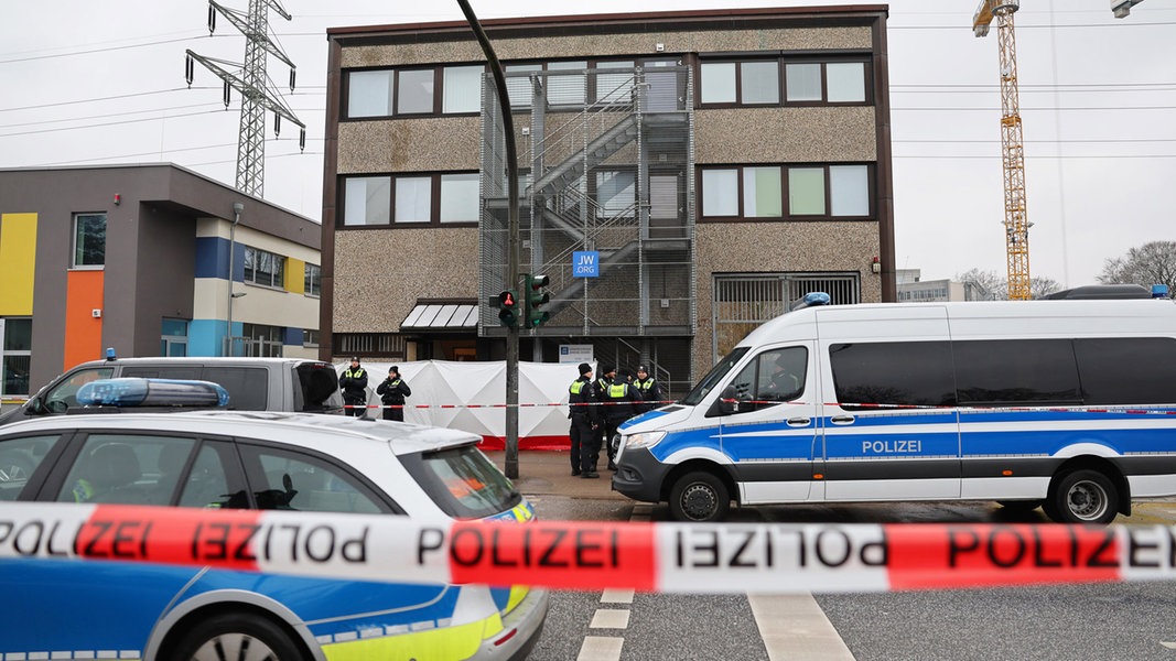 Polizisten stehen vor dem Gebäude der Zeugen Jehovas im Stadtteil Alsterdorf.