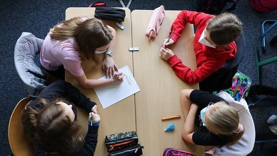 Schülerinnen in Hamburg sitzen sich mit Corona-Schutzmaske im Klassenraum gegenüber. © picture alliance/dpa Foto: Christian Charisius