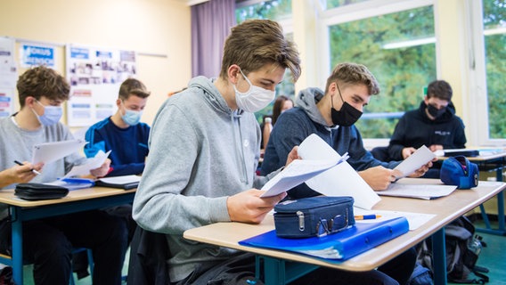 Schüler einer 13. Klasse der Oberstufe sitzen mit Mund-Nasen-Bedeckungen im Unterricht. © dpa Foto: Daniel Bockwoldt