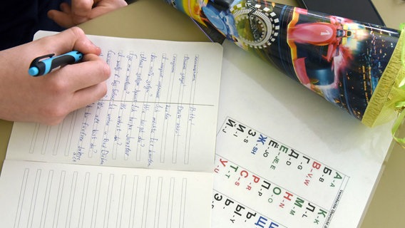 A teenager from Ukraine writes vocabulary in an exercise book next to a small school bag.  © picture alliance / dpa / dpa-Zentralbild Photo: Waltraud Grubitzsch