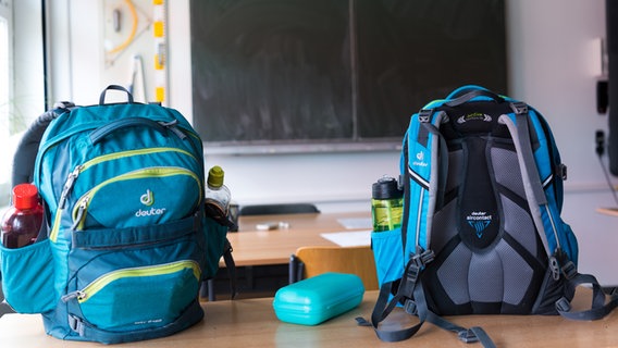 Zwei Rucksäcke stehen auf einer Schulbank in einem leeren Klassenraum. © dpa Foto: Monika Skolimowska