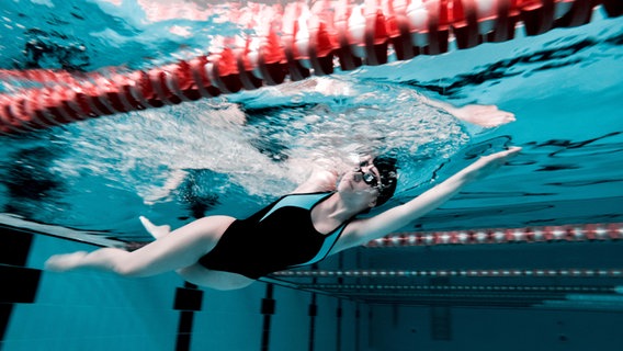 Eine Schwimmerin zieht ihre Bahnen in einem Schwimmbad. © Shotshop | Addictive Stock 