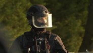 Ein Beamter der Polizei ist schwer bewaffnet. © TVNewsKontor Foto: Screenshot
