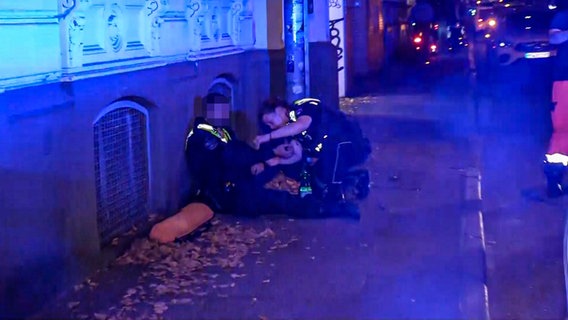 Ein verletzter Polizist wird von einer Kollegin behandelt. © NonstopNews 