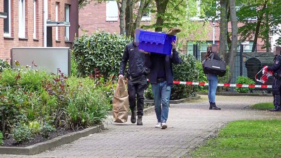 Zwei Polizisten stellen Beweismittel aus einem Wohngebäude in Hamburg sicher. © tv7news.de 