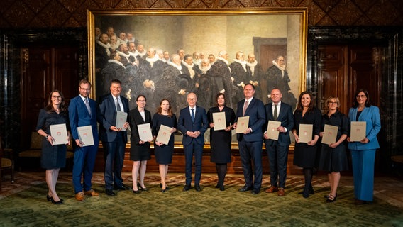 Die neuen Senatorinnen und Senatoren in Hamburg präsentieren ihre Berufungsurkunden. In der Mitte steht Hamburgs Bürgermeister Peter Tschentscher. © picture alliance / dpa Foto: Jonas Walzberg
